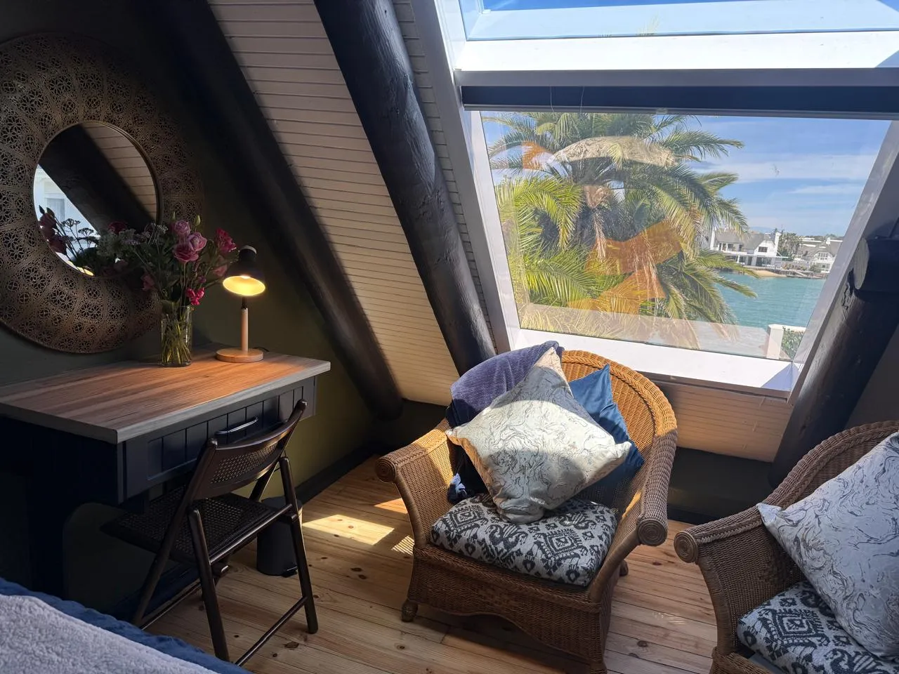 Canal Cottage's master bedroom with canal-view skylights overlooking palms and water