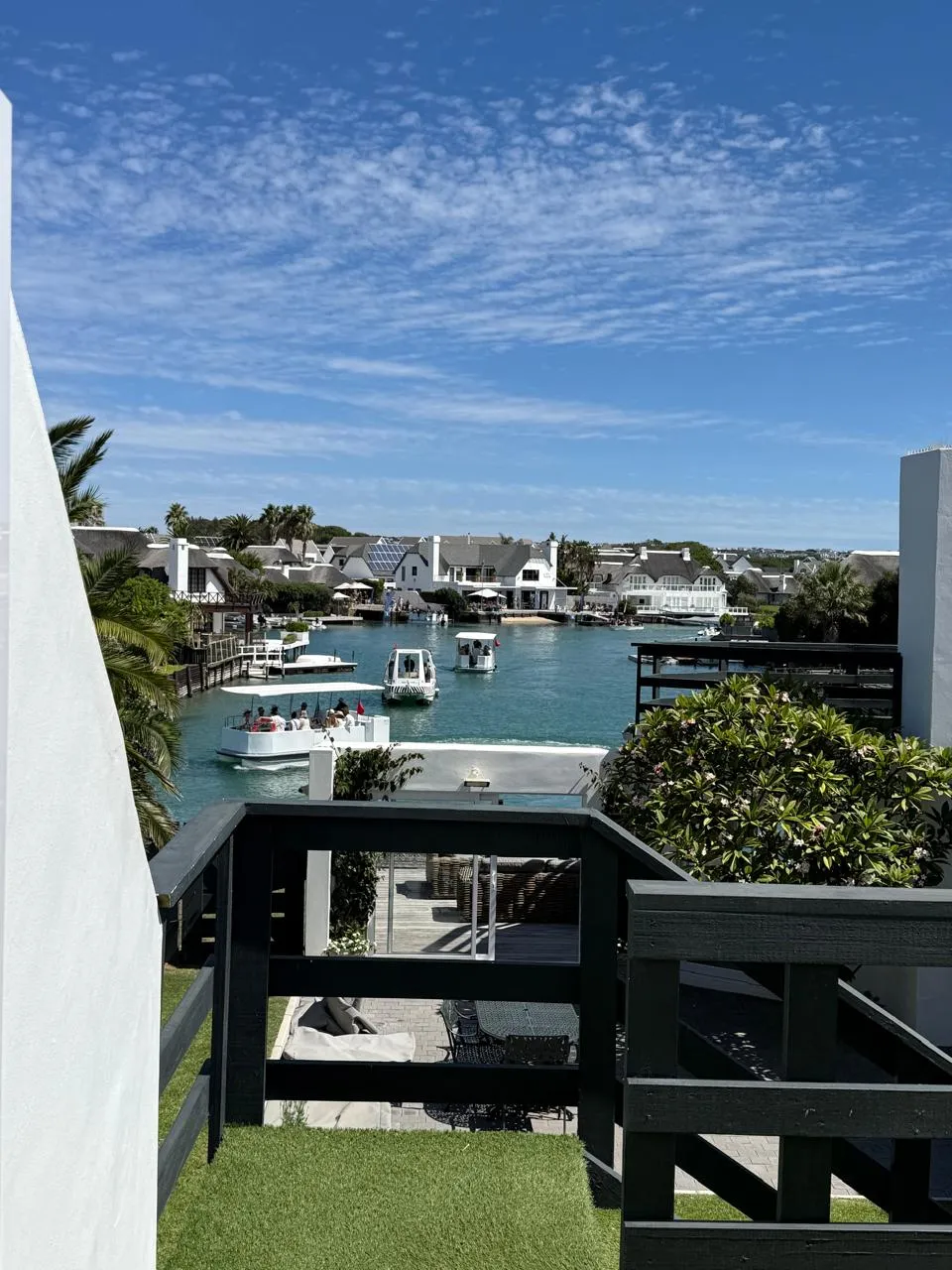 The St Francis Bay canal from the property deck, with moored boats and blue skies