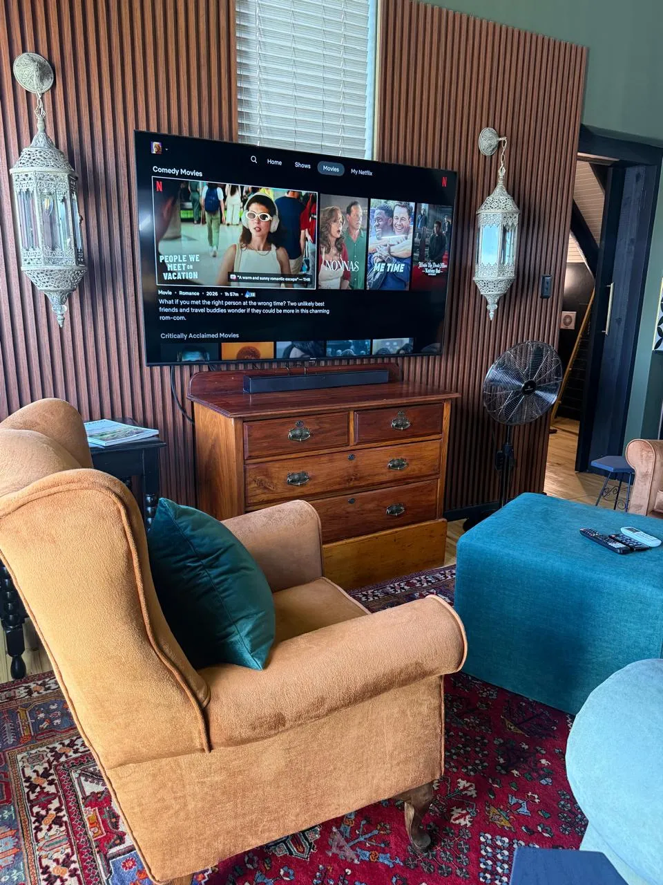 The lounge with a large TV, velvet armchairs, Moroccan lanterns and a patterned rug
