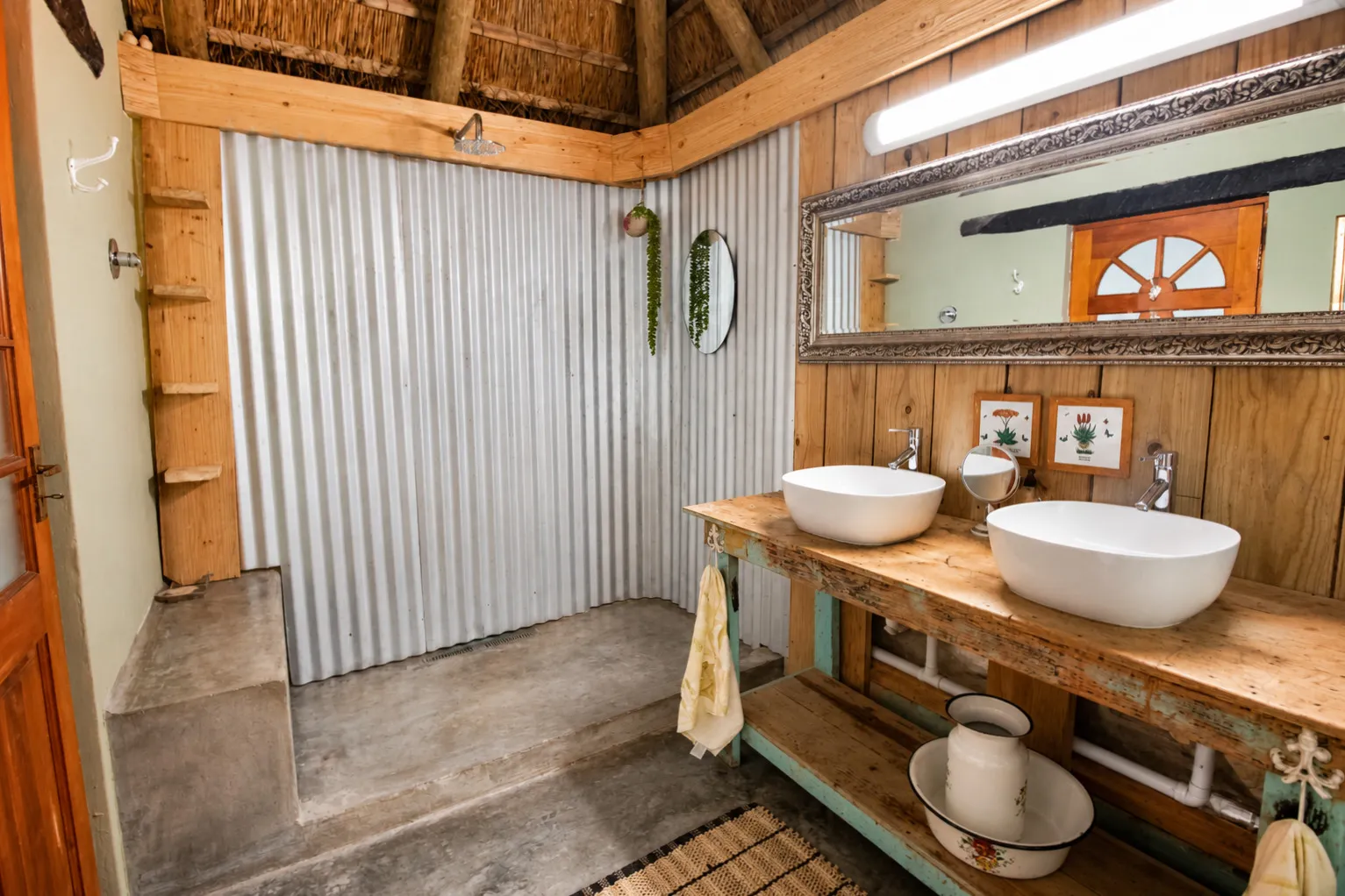 A rustic en-suite bathroom with a corrugated-iron shower and twin vessel basins on a reclaimed wood vanity