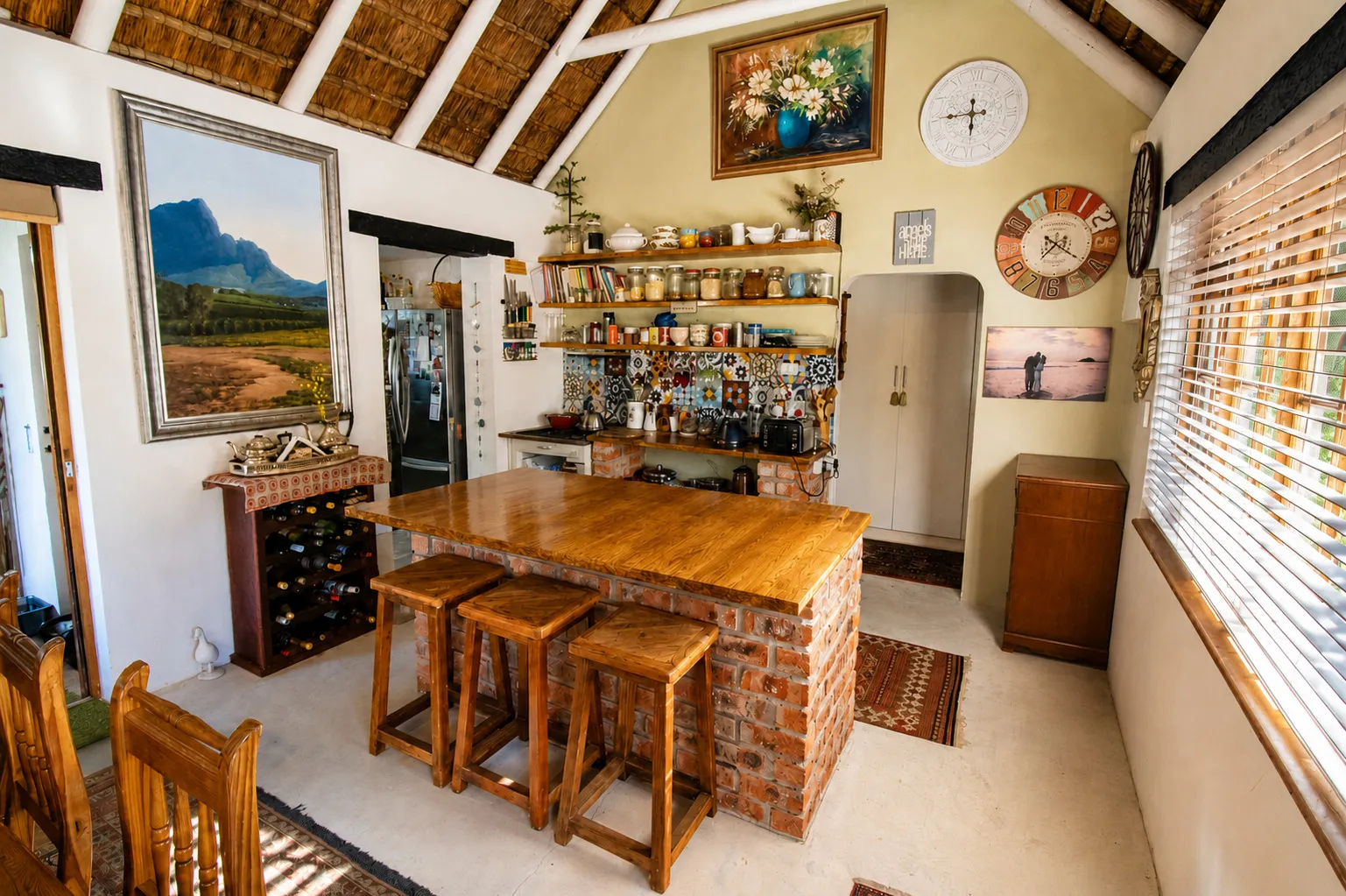 The kitchen with a brick-built breakfast bar, timber counter and bar stools