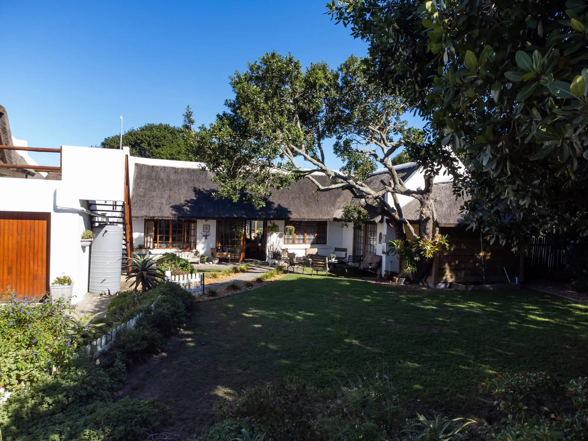 The Milkwood Way property and its walled garden, the thatched home across the lawn